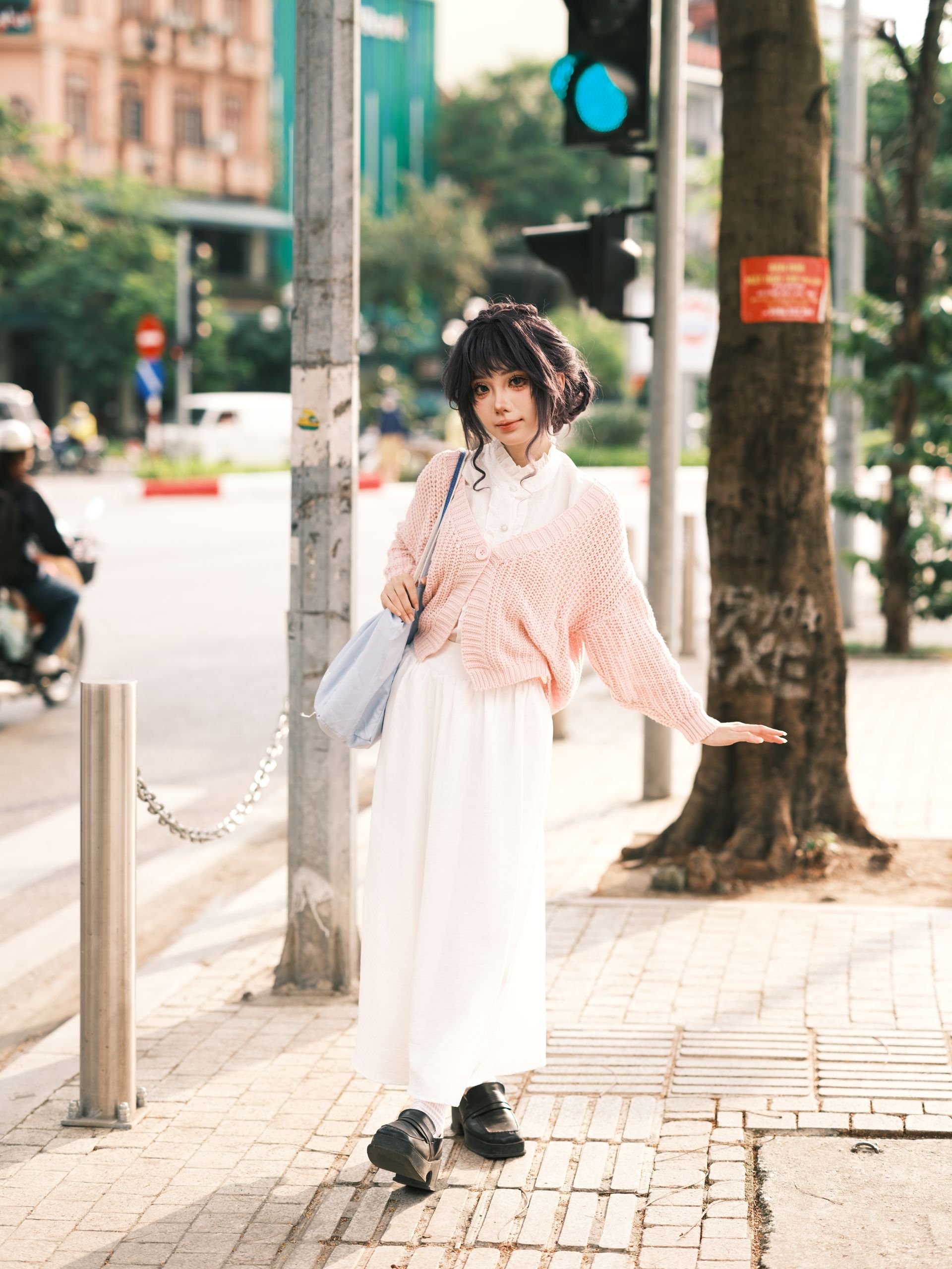 穿著淡粉色毛衣走在街頭的女生|穿搭沒有特色